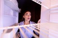 Desperate girl inspecting her empty refrigerator at home Royalty Free Stock Photo