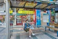 Coronavirus curfew in Antalya, young woman wearing protective face mask sits at bus stop.
