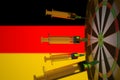 COVID-19 coronavirus disease vaccine syringes hit target near the German flag. Successful research and vaccination in