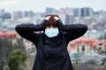 Coronavirus disease and world pollution panic: woman in medical mask on a city background