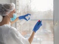 Coronavirus disinfection. People in making disinfection on windows. Doctor in rubber gloves disinfects windows with disinfectant