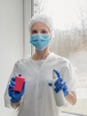 Coronavirus disinfection. People in making disinfection on windows. Doctor in rubber gloves disinfects windows with disinfectant