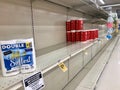 Toilet tissue is on an otherwise empty grocery store shelf