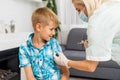 Coronavirus, flu or measles vaccine concept. Medic, doctor, nurse, health practitioner vaccinates teenage boy with