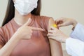 Coronavirus hand of young woman nurse,doctor giving syringe vaccine, inject shot to asian arm's patient. Vaccination, Royalty Free Stock Photo