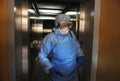 Coronavirus infection. Paramedic in protective mask and costume disinfecting elevator with sprayer Royalty Free Stock Photo