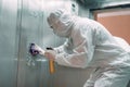 Coronavirus infection. Paramedic in protective mask and costume disinfecting an elevator with sprayer, Royalty Free Stock Photo