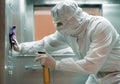 Coronavirus infection. Paramedic in protective mask and costume disinfecting an elevator with sprayer, Royalty Free Stock Photo