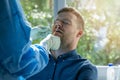 Coronavirus nasal swab test - lab worker taking a mucus sample from male patient nose