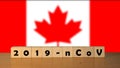 Coronavirus 2019-nCov words made of wood blocks. Covid 19 concept background with Canada flag