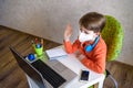 Coronavirus Outbreak. Lockdown and school closures. School boy with face mask watching online education classes feeling bored and Royalty Free Stock Photo