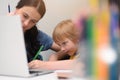 Coronavirus Outbreak. Lockdown and school closures. Mother helping her son studying online classes at home. COVID-19 pandemic