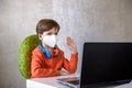 Coronavirus Outbreak. Lockdown and school closures. School boy with face mask watching online education classes feeling bored and Royalty Free Stock Photo