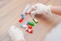 Virus and recovery concept, hands with plastic surgery gloves touching one of a group of vaccine bottles