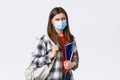 Coronavirus pandemic, covid-19 education, and back to school concept. Displeased female student in medical mask and