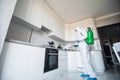 Coronavirus Pandemic. A disinfector in a protective suit and mask sprays disinfectants in house. Protection against COVID-19