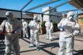 Coronavirus Pandemic. A disinfectors in a protective suit and mask spray disinfectants in the house or office