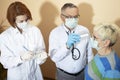 Coronavirus pandemic. Doctors in medical masks and gloves measure the temperature with a thermometer Royalty Free Stock Photo