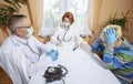 Coronavirus pandemic. Doctors in medical masks and gloves measure the temperature with a thermometer Royalty Free Stock Photo