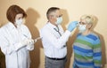 Coronavirus pandemic. Doctors in medical masks and gloves measure the temperature with a thermometer Royalty Free Stock Photo