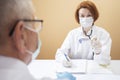 Coronavirus pandemic. Doctors in medical masks and gloves measure the temperature with a thermometer Royalty Free Stock Photo