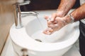 Coronavirus prevention concept - man washing hands with soap and tap water