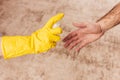 Coronavirus protection - carelessly outstretched hand for a handshake - a man in a rubber glove sprays