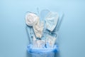 Used disposable medical face masks, latex medical gloves, syringes and test tubes on pastel blue background Royalty Free Stock Photo