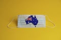 Coronavirus protective mask. Medical mask with Australia flag and maps. Yellow background. Face mask protection against pollution