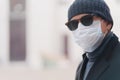 Coronavirus, quarantine and pandemic disease concept. Sideways shot of European man wears shades and disposable medical mask, Royalty Free Stock Photo