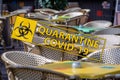 Coronavirus quarantine sign on the background of an empty wicker chairs and colorful tables in the outdoor cafe Royalty Free Stock Photo