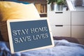 coronavirus quote stay home, save lives grey board sign with message of self isolation for social responsability on home