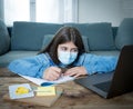 Coronavirus school closures and lockdown. Bored kid with face mask studying online class at home Royalty Free Stock Photo