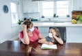 Coronavirus school closures and lockdown. Mum and bored daughter with masks studying online at home