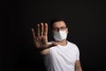 Coronavirus stop concept.Man in wearing mask for protect and show stop hands gesture for stop corona virus outbreak.Wuhan