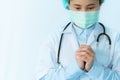 Coronavirus stop infection. young female doctor wearing mask with stethoscope pray for virus infected person. Healthcare concept
