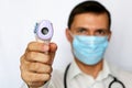 Coronavirus symptoms, man in medical mask measures body temperature Royalty Free Stock Photo