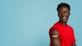 Coronavirus Vaccination Campaign. Portrait Of Black Guy With Adhesive Band On Arm Royalty Free Stock Photo