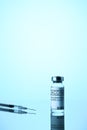 Coronavirus vaccination concept. Vial COVID-19 vaccine, and medical syringe on blue background