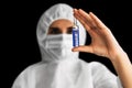Coronavirus vaccine. A doctor in protective clothing and a mask holds medicine for the coronavirus.