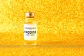 Coronavirus vaccine. Vaccine values during the acute period of the covid-19 pandemic concept. Vial on a golden