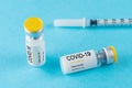 Coronavirus vaccine vial glass with a syringe on blue background.  Covid-19 medicine vaccination concept. World pandemic concept Royalty Free Stock Photo