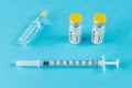 Coronavirus vaccine vial glass with a syringe on blue background.  Covid-19 medicine vaccination concept. World pandemic concept Royalty Free Stock Photo