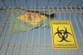 Coronavirus warning sign on the barbed wire fence against flag of Delaware. COVID-19 quarantine related 3D rendering