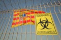Coronavirus warning sign on the barbed wire fence near flag of Aragon, an autonomous community in Spain. COVID-19