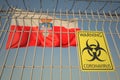 Biohazard coronavirus sign on the barbed wire fence near flag of Cantabria, an autonomous community in Spain. COVID-19