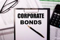 CORPORATE BONDS written on a white piece of paper next to the glasses. reports and calculator. Business concept Royalty Free Stock Photo