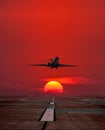 Business jet take off from airport runway against the backdrop crimson sunrise