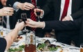 Corporate business man toasting at dinner party table hands close-up, wedding reception guests toast alcohol drinks in glasses