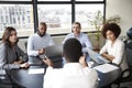 Corporate business people in a meeting room listening to a colleague speaking, elevated view